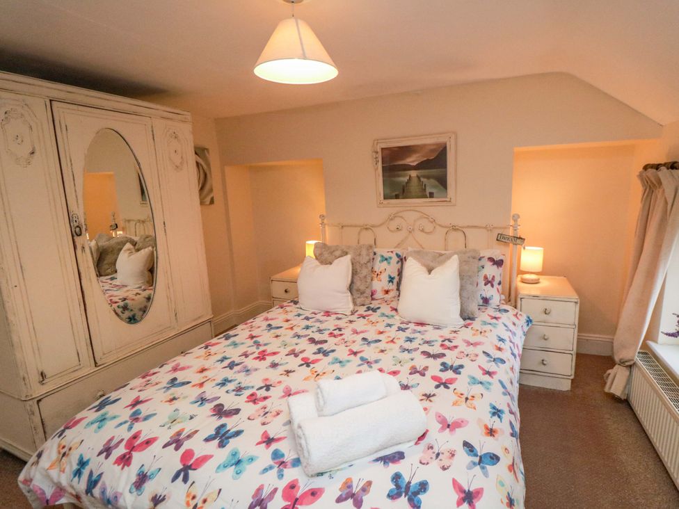 A bedroom with a bed and wardrobe at Jasmine Cottage Dalton Near Thirsk
