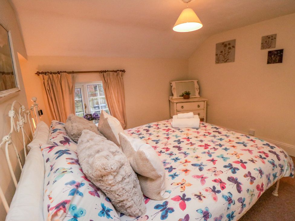 A bedroom with a bed and a bedside table at Jasmine Cottage Dalton Near Thirsk