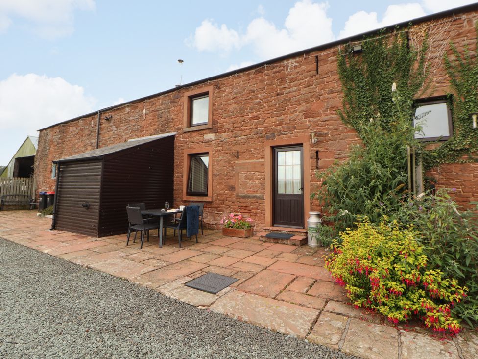 An outdoor area with a table and chairs at Hayloft Cottage in Bolton Low Houses