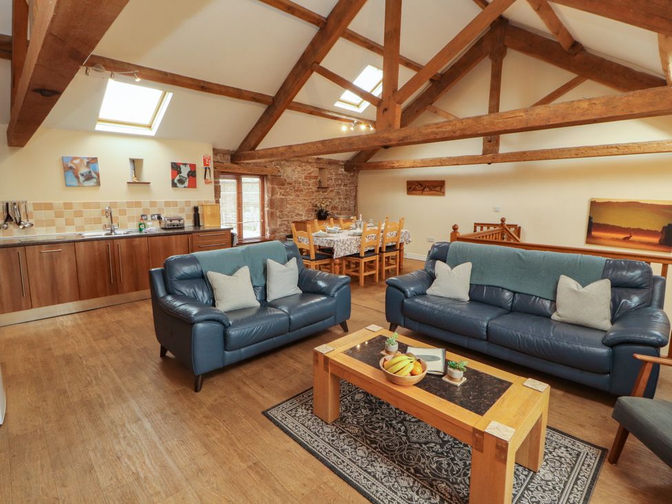 A living room with a sofa and dining area at Hayloft Cottage in Bolton Low Houses