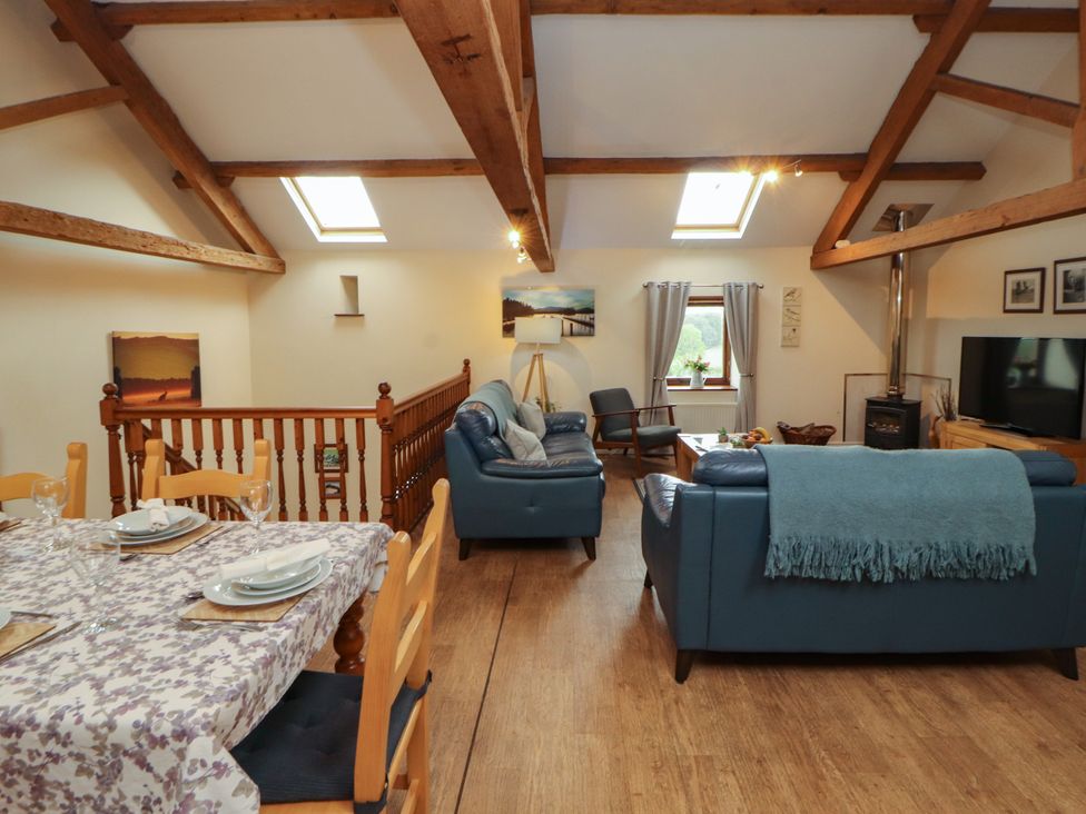 A living room with a sofa and dining area at Hayloft Cottage Bolton Low Houses