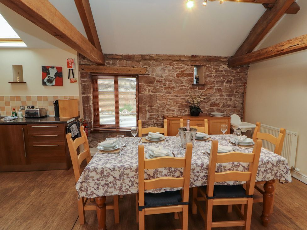 A dining room with a table set for dinner at Hayloft Cottage in Bolton Low Houses