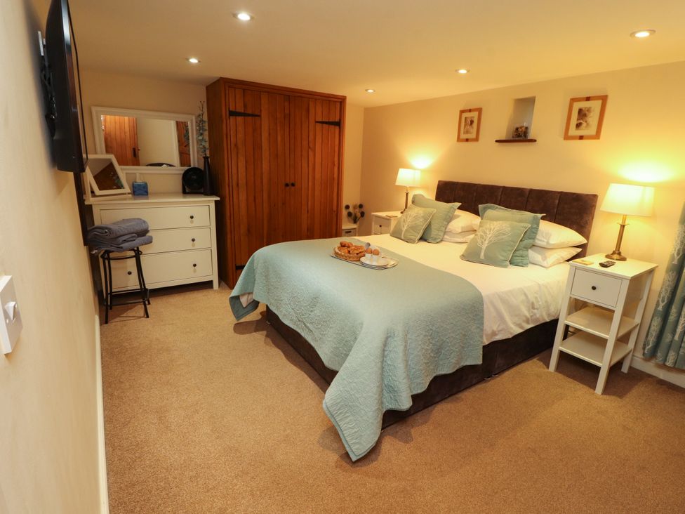 A bedroom with a double bed and wooden wardrobe at Hayloft Cottage Bolton Low Houses