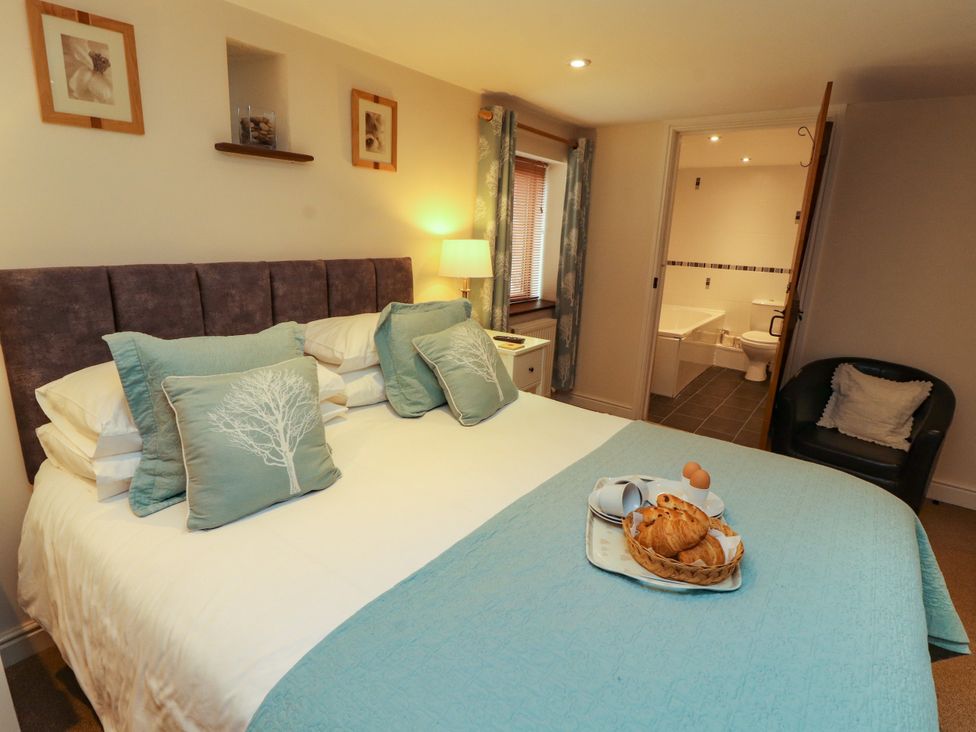 A bedroom with a bed and breakfast items at Hayloft Cottage Bolton Low Houses