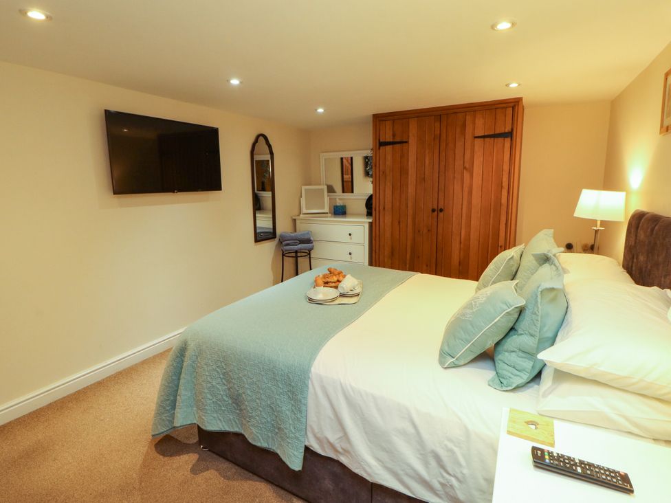 A bedroom with a bed and television at Hayloft Cottage Bolton Low Houses