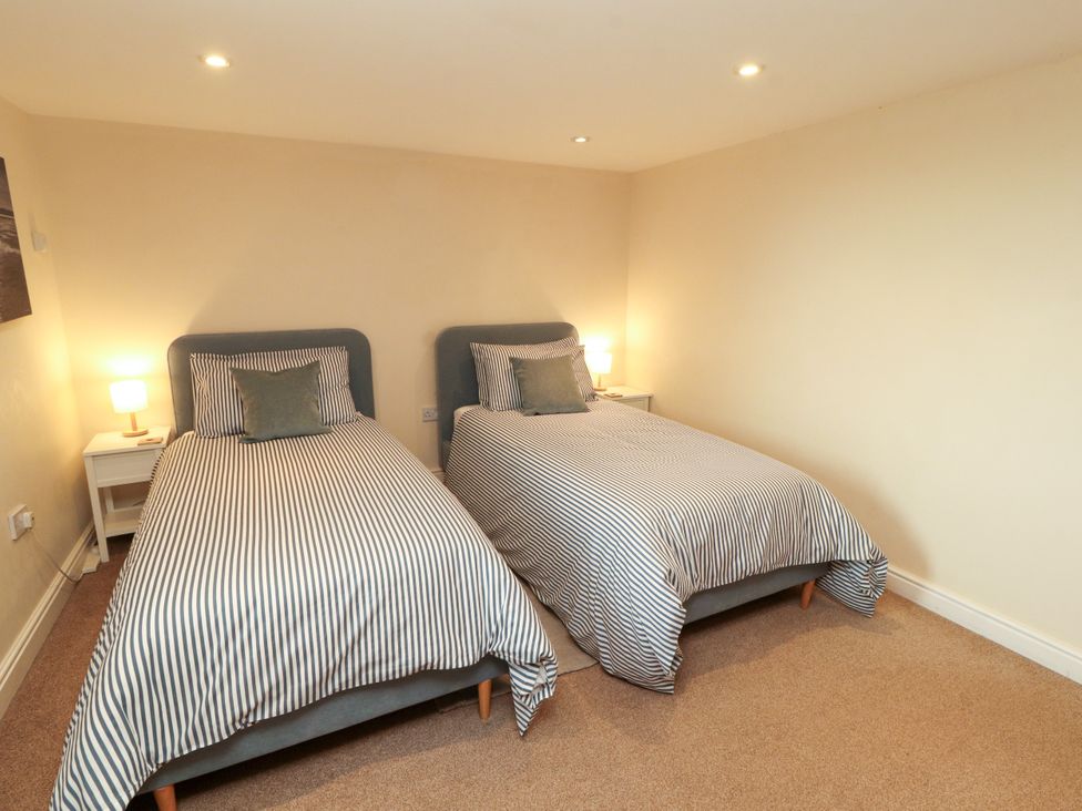A bedroom with two beds and bedside tables at Hayloft Cottage Bolton Low Houses