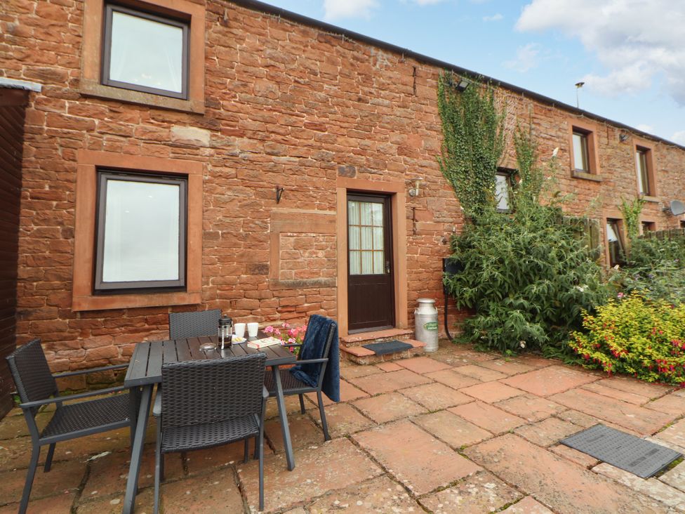 An outdoor area with a table and chairs at Hayloft Cottage Bolton Low Houses