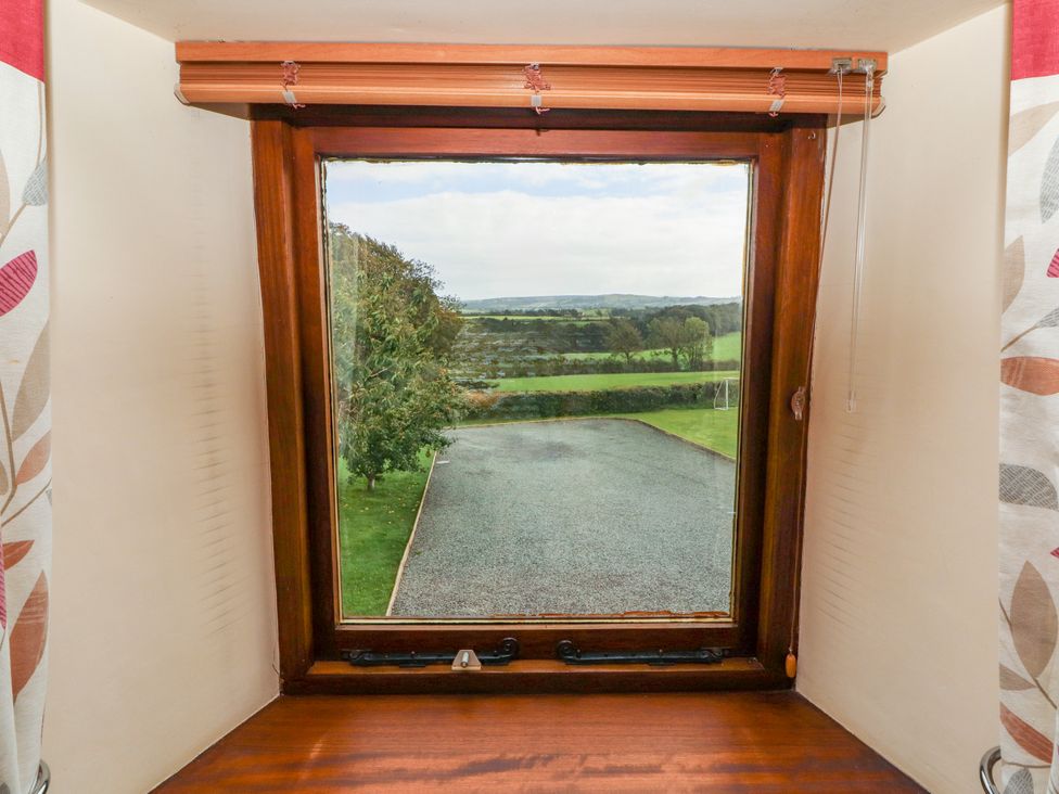 A view from a window showing grass and gravel outside at Horseshoe Cottage in Bolton Low Houses