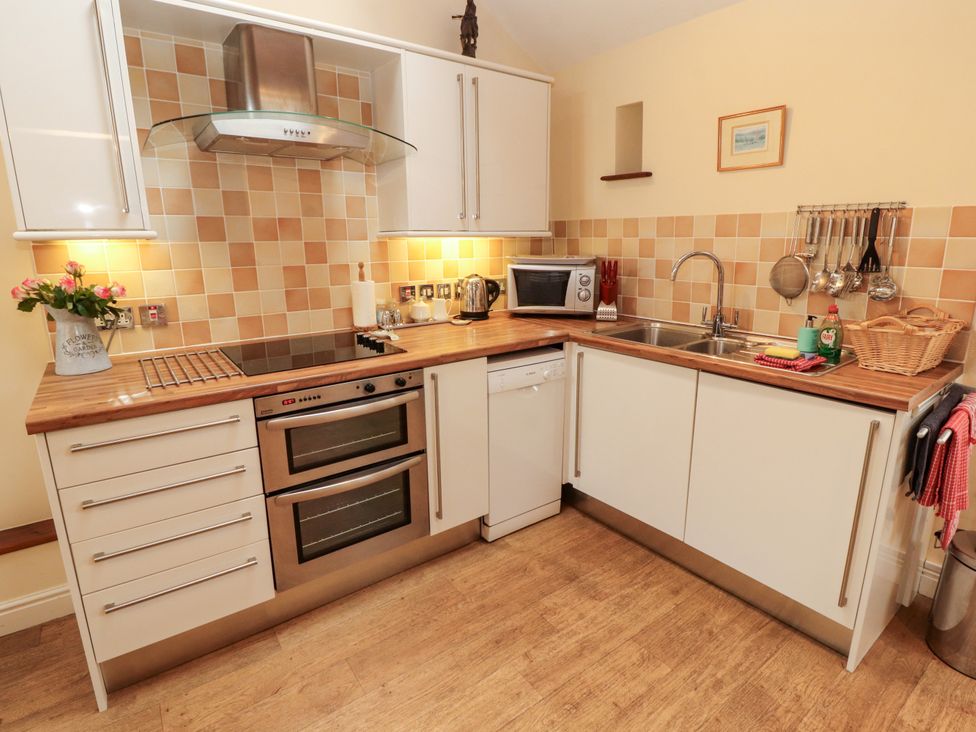 A kitchen with appliances and wooden countertops at Horseshoe Cottage in Bolton Low Houses