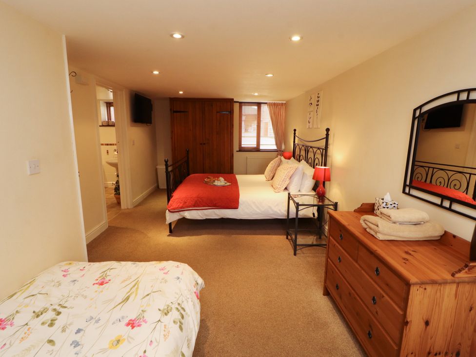A bedroom with double and single beds at Horseshoe Cottage in Bolton Low Houses