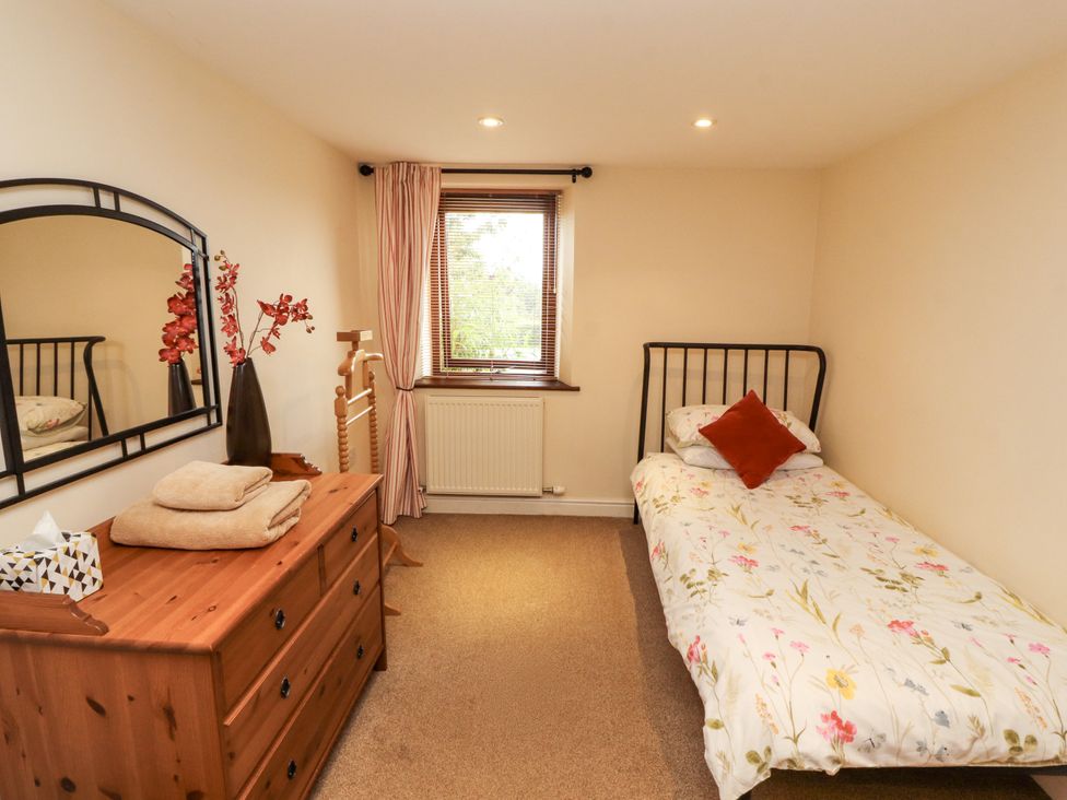 A bedroom with a bed and dresser at Horseshoe Cottage in Bolton Low Houses