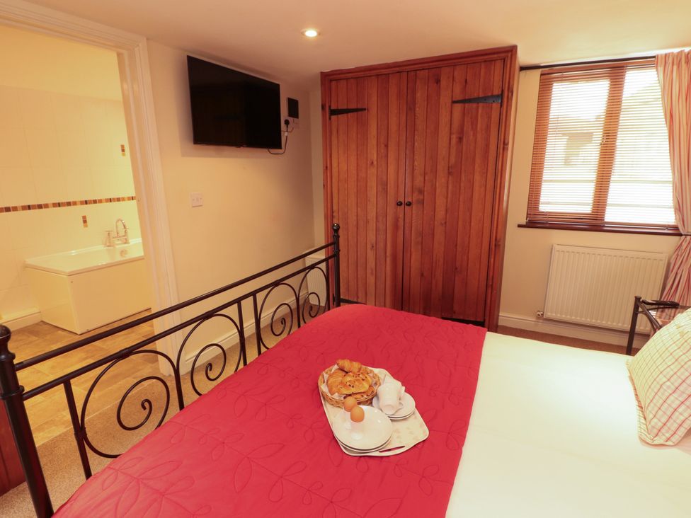 A bedroom with a bed and wardrobe at Horseshoe Cottage in Bolton Low Houses