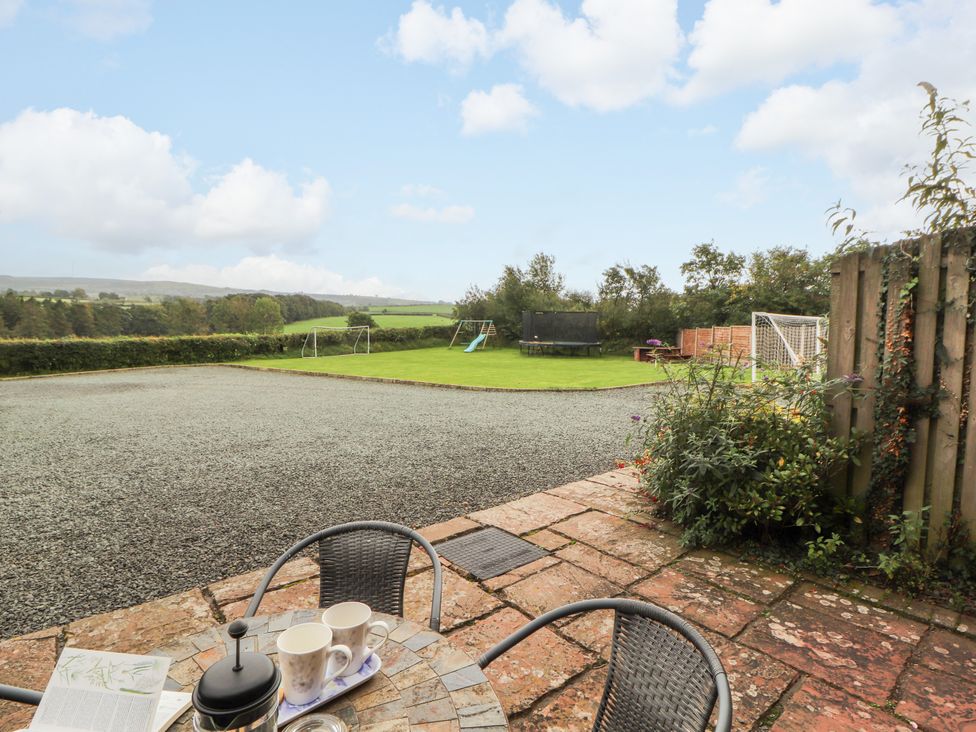 A garden with seating and playground equipment at Horseshoe Cottage in Bolton Low Houses