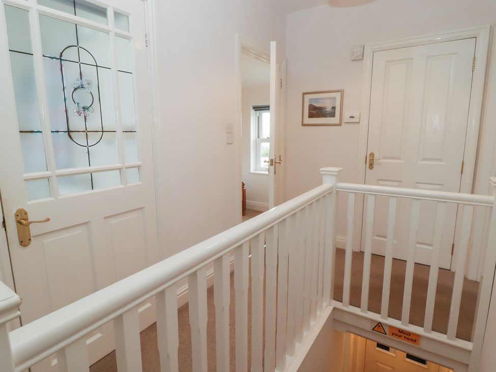 A hallway with a door and window at Garth Cottage in Haverfordwest