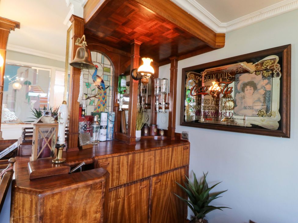 A bar counter with bottles and a decorative mirror at Boathouse in Deganwy near Llandudno