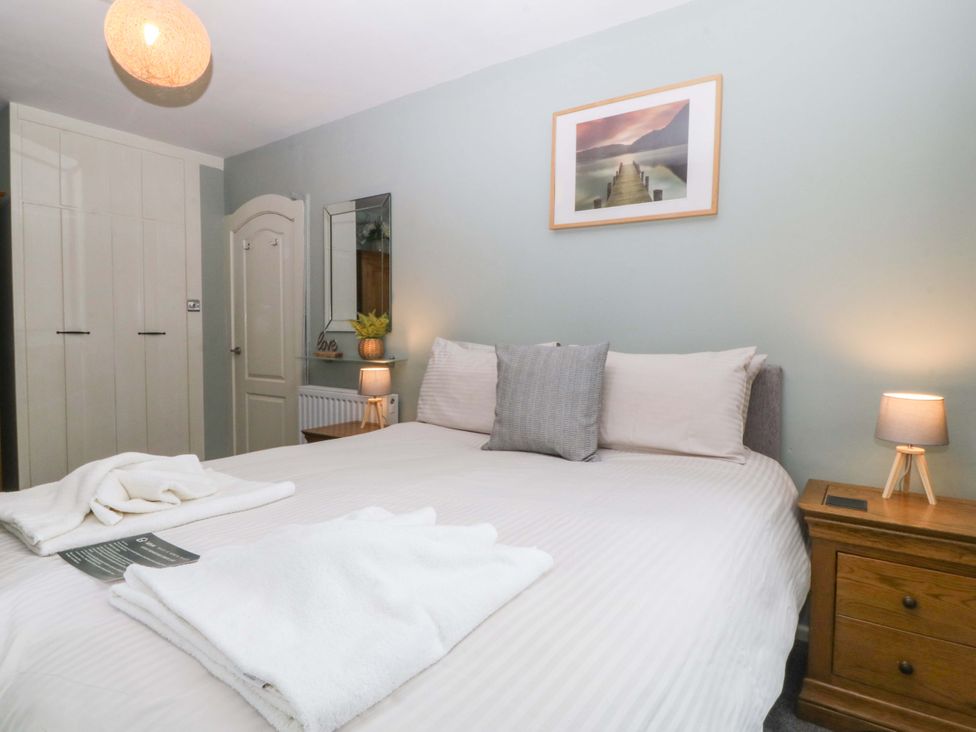 A bedroom with a bed and wardrobe at Boathouse in Deganwy near Llandudno