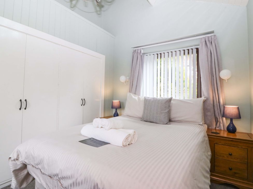 A bedroom with a bed and wardrobe at Boathouse in Deganwy near Llandudno