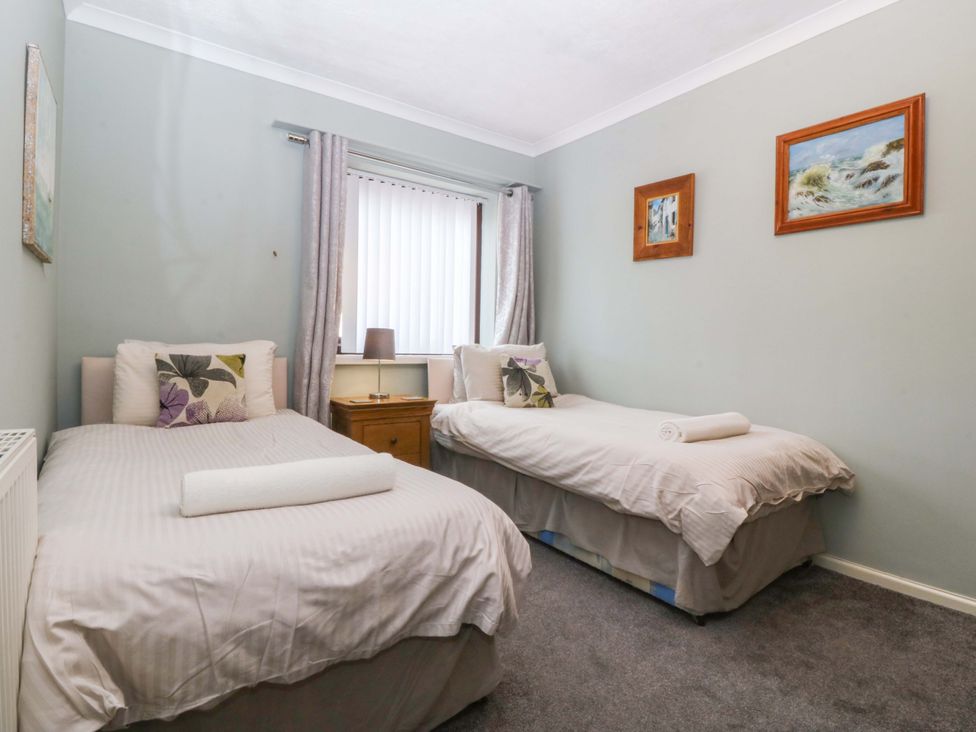 A bedroom with two beds and a bedside table at Boathouse in Deganwy near Llandudno