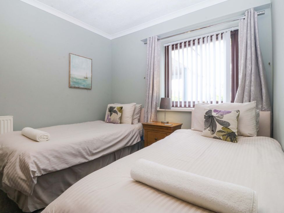 A bedroom with two single beds and a bedside table at Boathouse in Deganwy near Llandudno