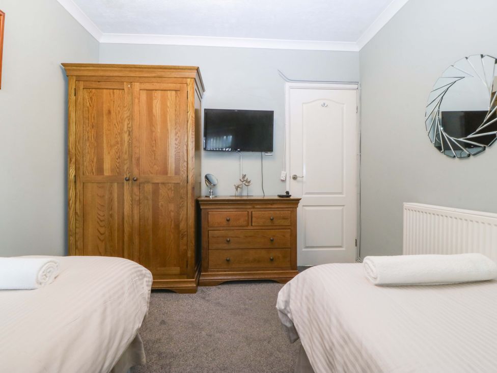 A bedroom with twin beds and a wardrobe at Boathouse in Deganwy near Llandudno