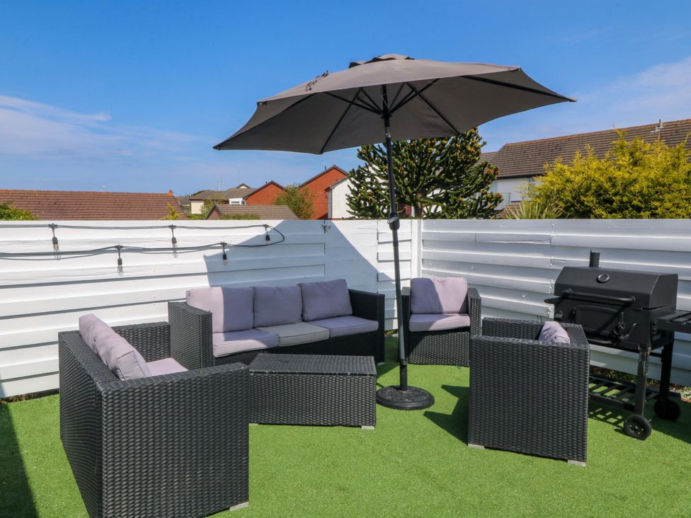 A garden area with seating and barbecue grill at Boathouse in Deganwy near Llandudno