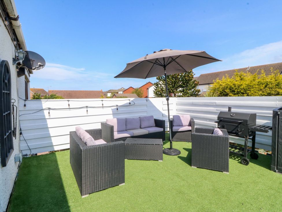 A patio area with furniture and a grill at the Boathouse in Deganwy near Llandudno