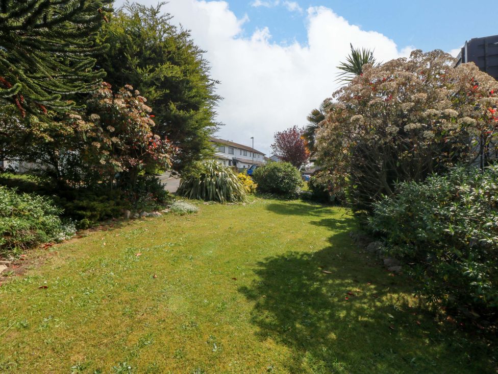 A garden with grass, trees, and shrubs at Boathouse in Deganwy near Llandudno