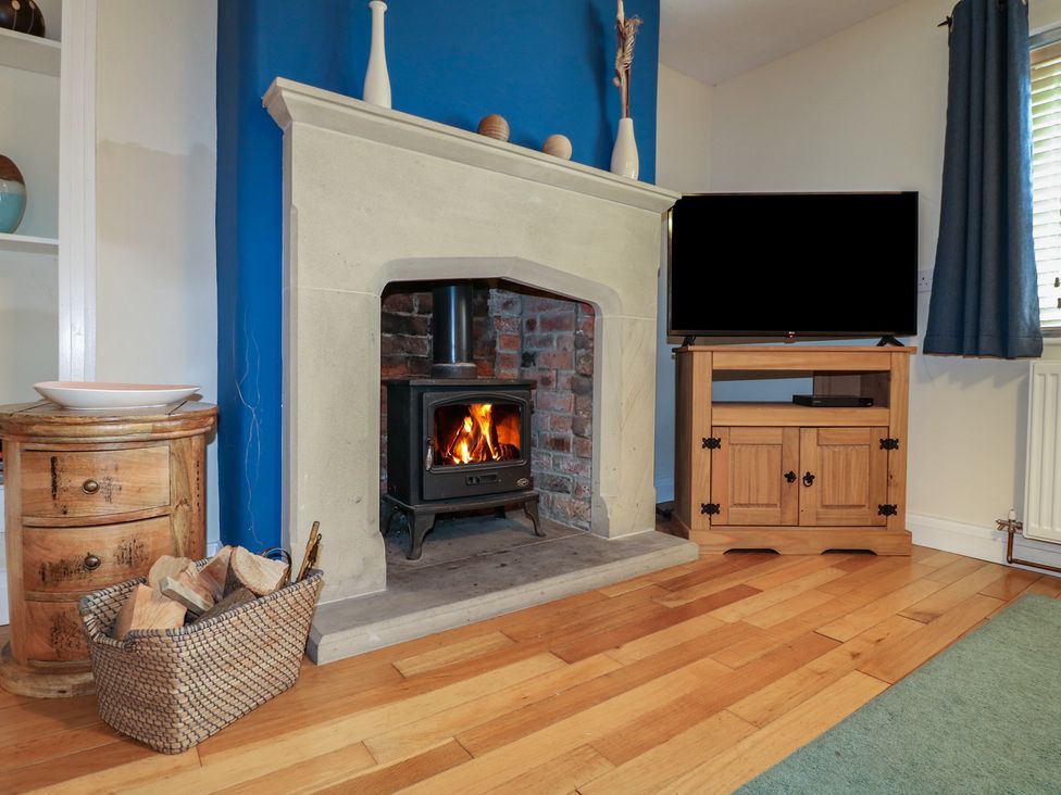 A living room with a fireplace and television at Ash House in Alton near Alton Towers