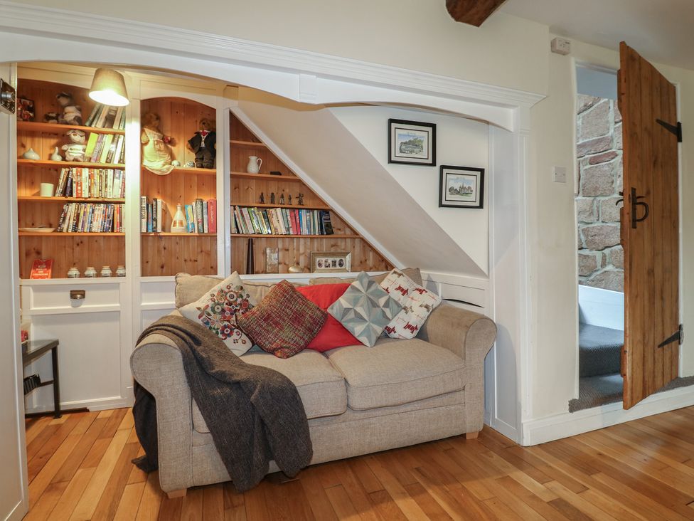 A snug with a sofa and bookshelves at Ash House in Alton near Alton Towers