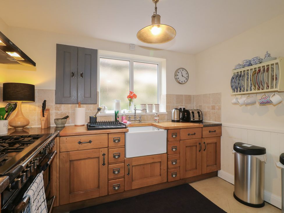 A kitchen with a sink, stove, and cabinets at Ash House in Alton near Alton Towers