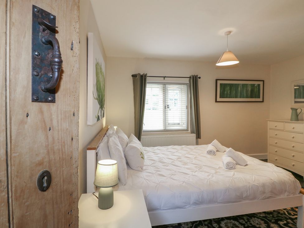A bedroom with a bed and window at Ash House in Alton near Alton Towers