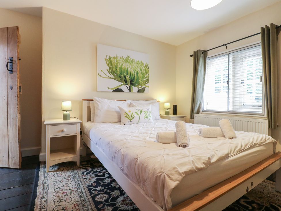 A bedroom with a bed and nightstand at Ash House in Alton near Alton Towers