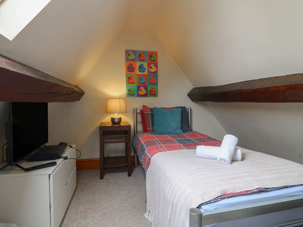 A bedroom with a bed, television, and lamp at Ash House in Alton near Alton Towers