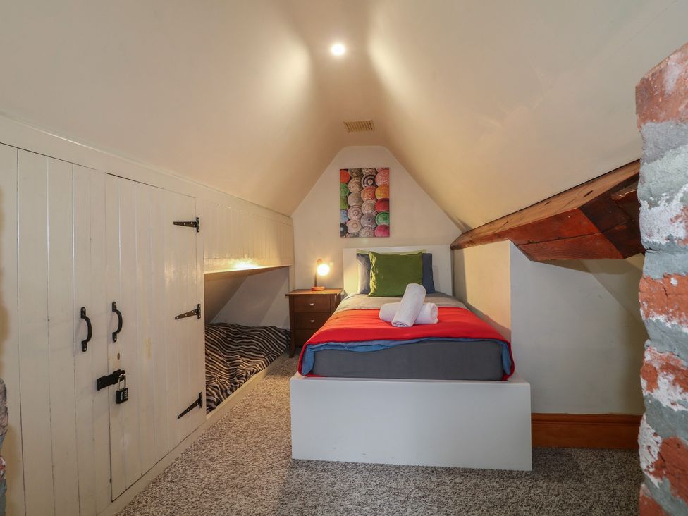 A bedroom with a bed and storage cabinets at Ash House in Alton near Alton Towers