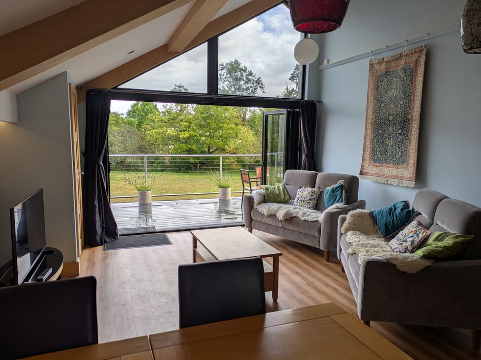 A living room with sofas and a table at Cointree in Sturminster Newton
