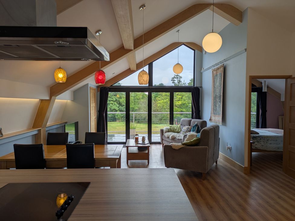 A living room with a sofa and dining table at Cointree in Sturminster Newton