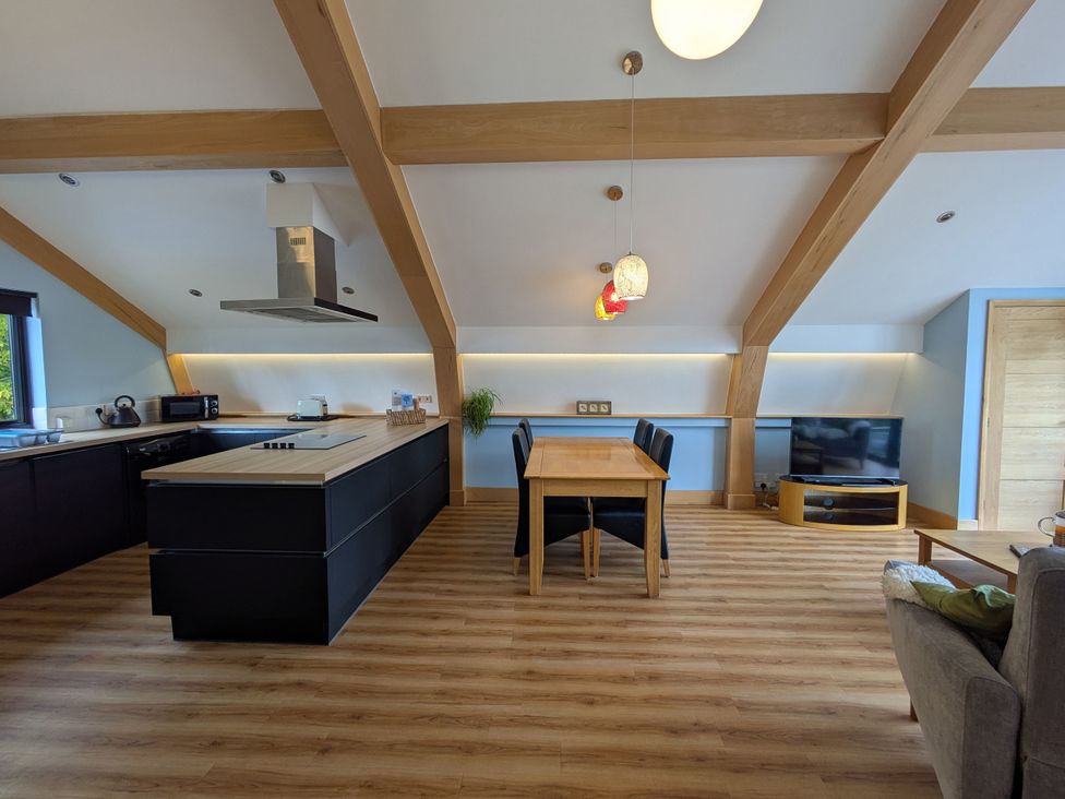 A kitchen with a dining table and black chairs at Cointree in Sturminster Newton