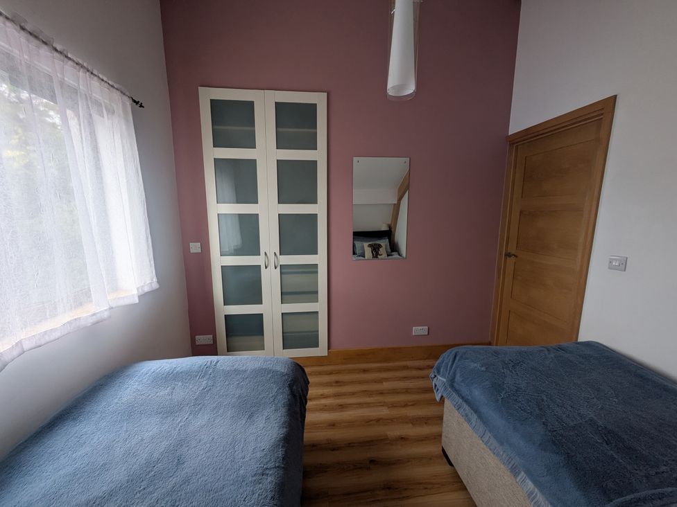 A bedroom with two beds and a wardrobe at Cointree in Sturminster Newton