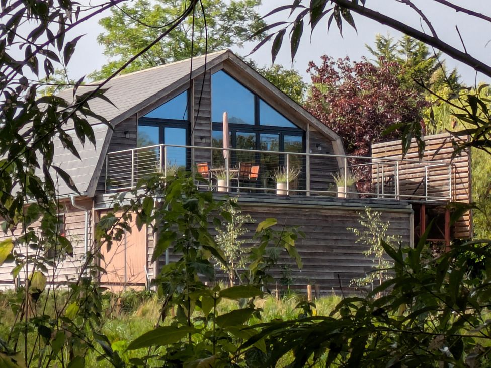 A house with a balcony and chairs at Cointree Sturminster Newton