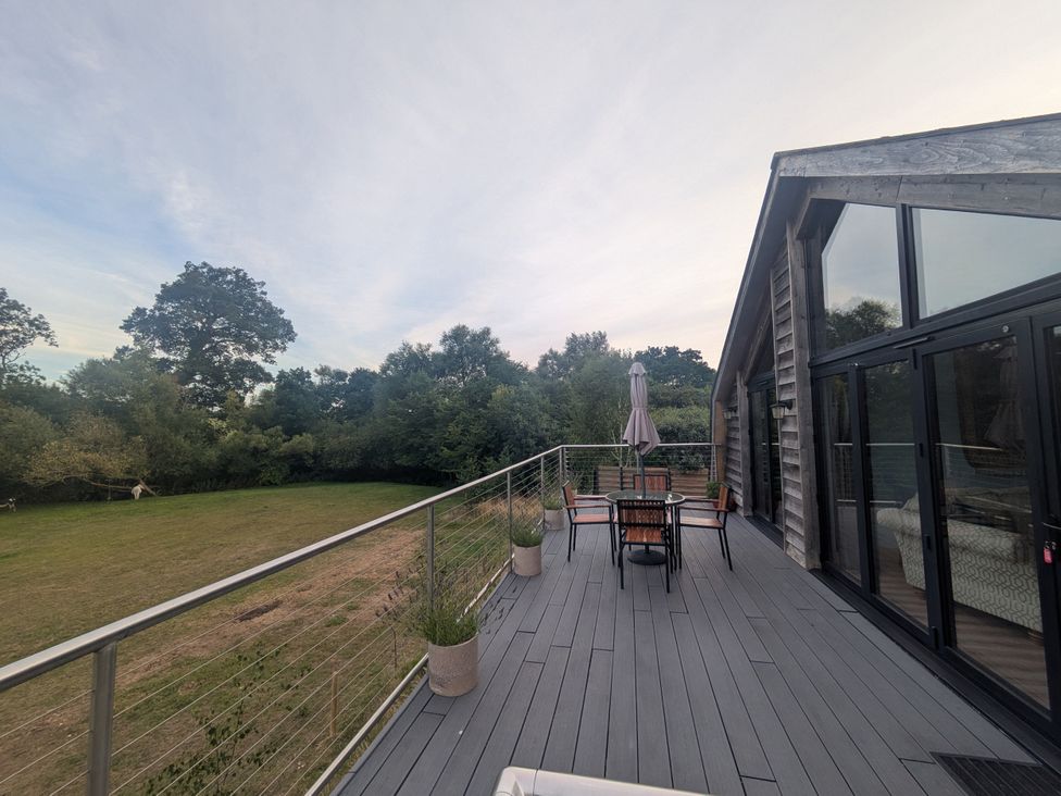 A deck area with a table and chairs at Cointree in Sturminster Newton