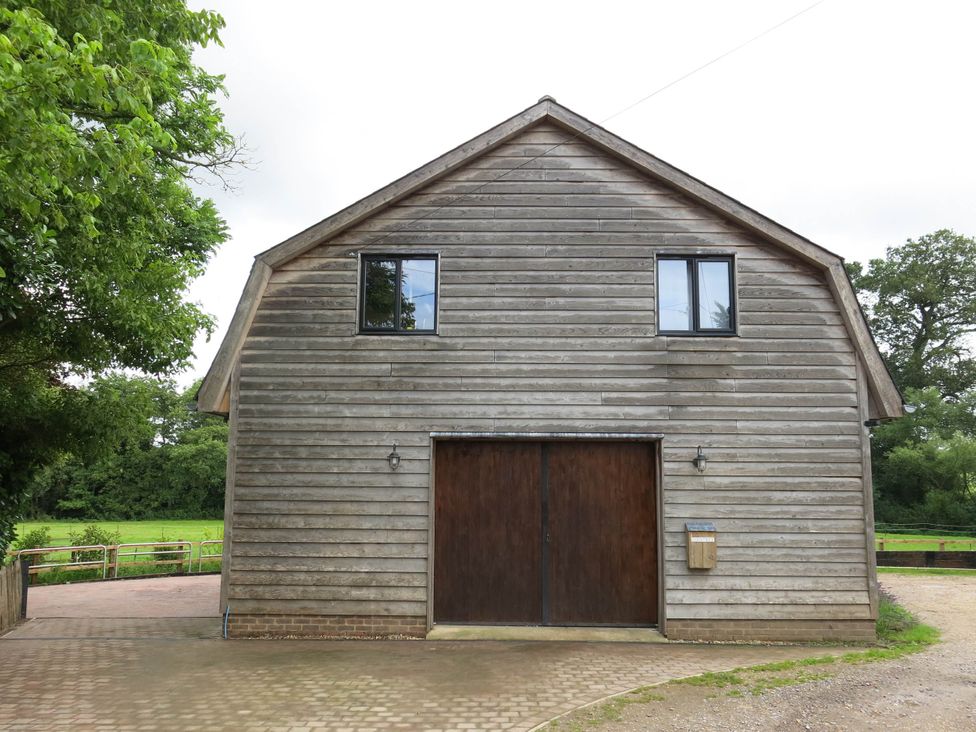 A wooden barn building with windows and a door at Cointree in Sturminster Newton