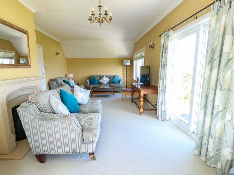 A living room with a sofa and television at Bryn y Don in Benllech