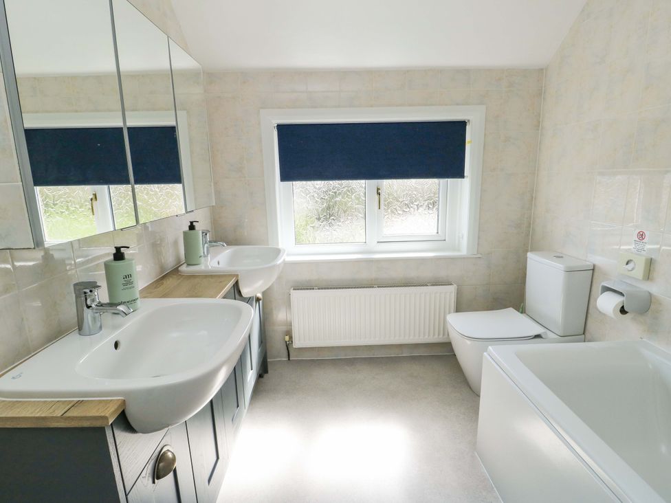 A bathroom with two sinks and a bathtub at Bryn y Don in Benllech