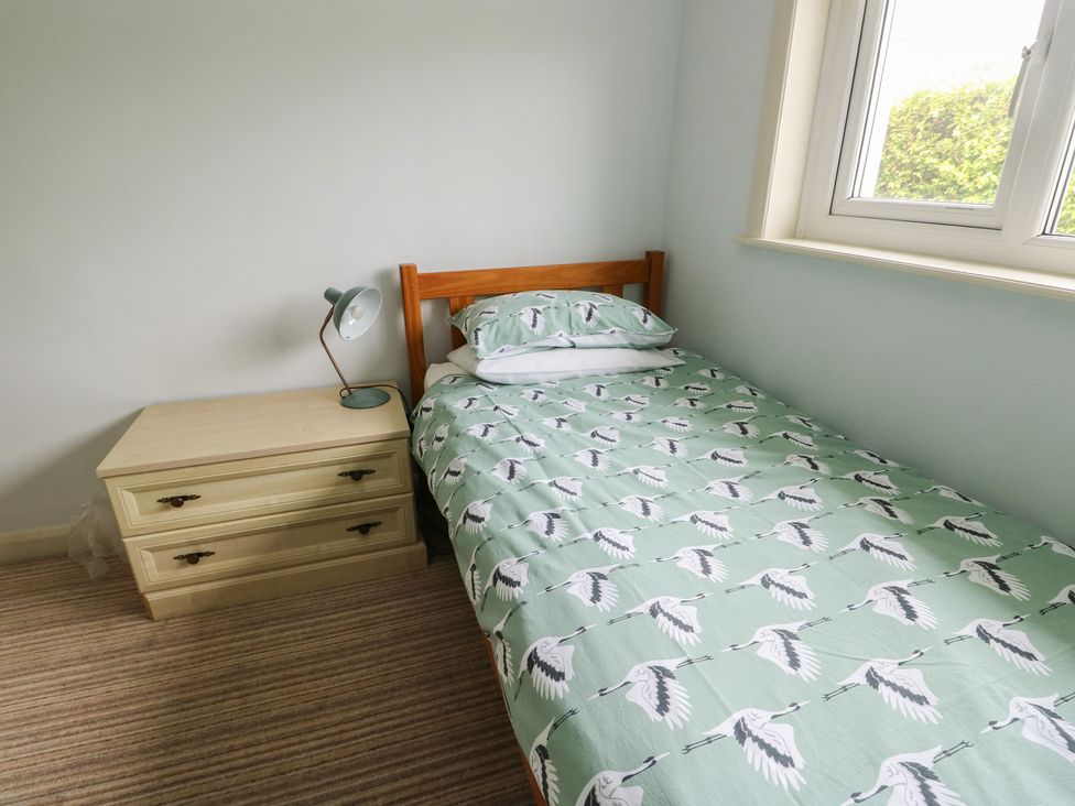 A bedroom with a bed and bedside table at Bryn y Don in Benllech