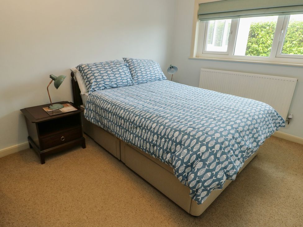 A bedroom with a bed and bedside table at Bryn y Don in Benllech