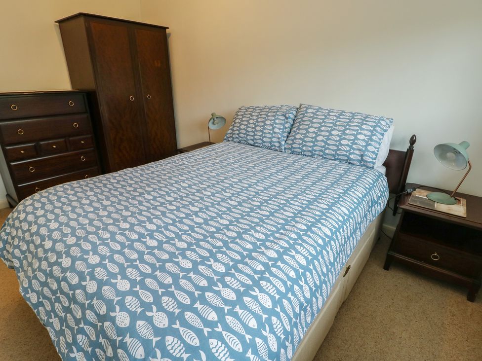A bedroom with a bed and furniture at Bryn y Don in Benllech