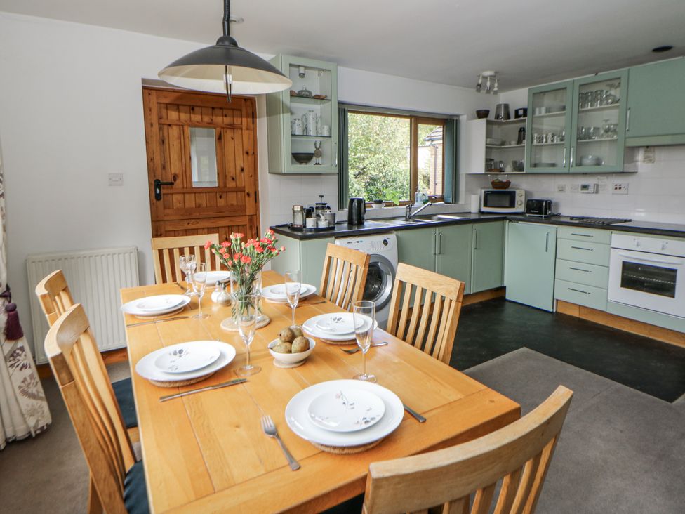 A kitchen with a dining table and chairs at Geryllan in Rhandirmwyn near Llandovery