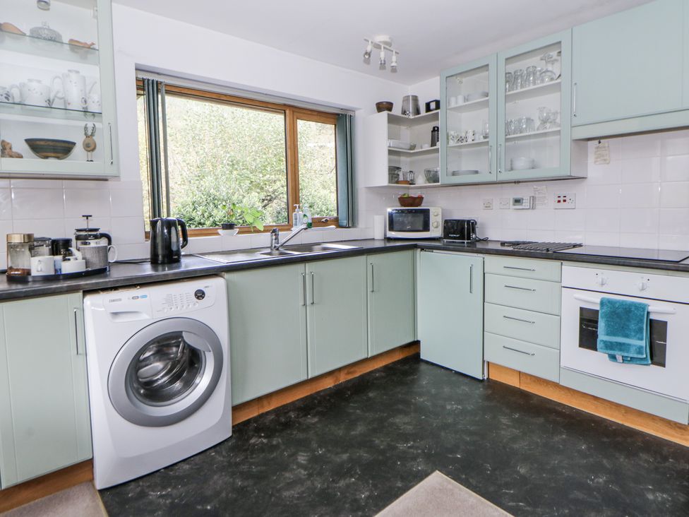 A kitchen with appliances and cabinetry at Geryllan Rhandirmwyn near Llandovery