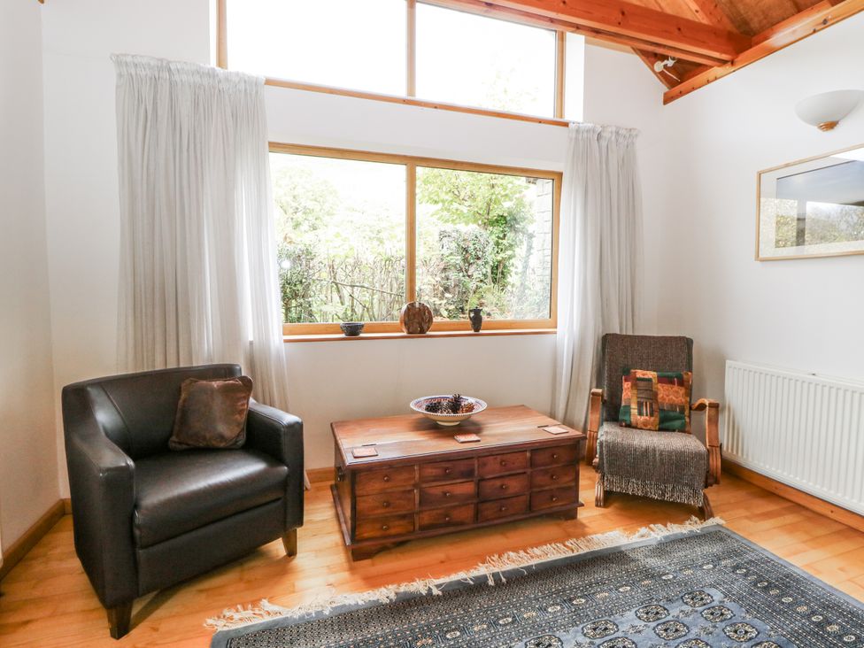 A living room with a coffee table and two chairs at Geryllan in Rhandirmwyn near Llandovery