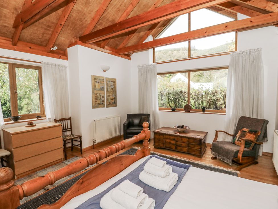 A bedroom with a bed and wooden furniture at Geryllan in Rhandirmwyn near Llandovery